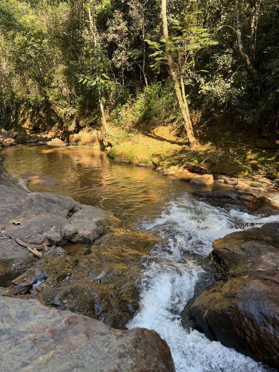 Rio com quedas d'água entre as pedras, dentro do sítio